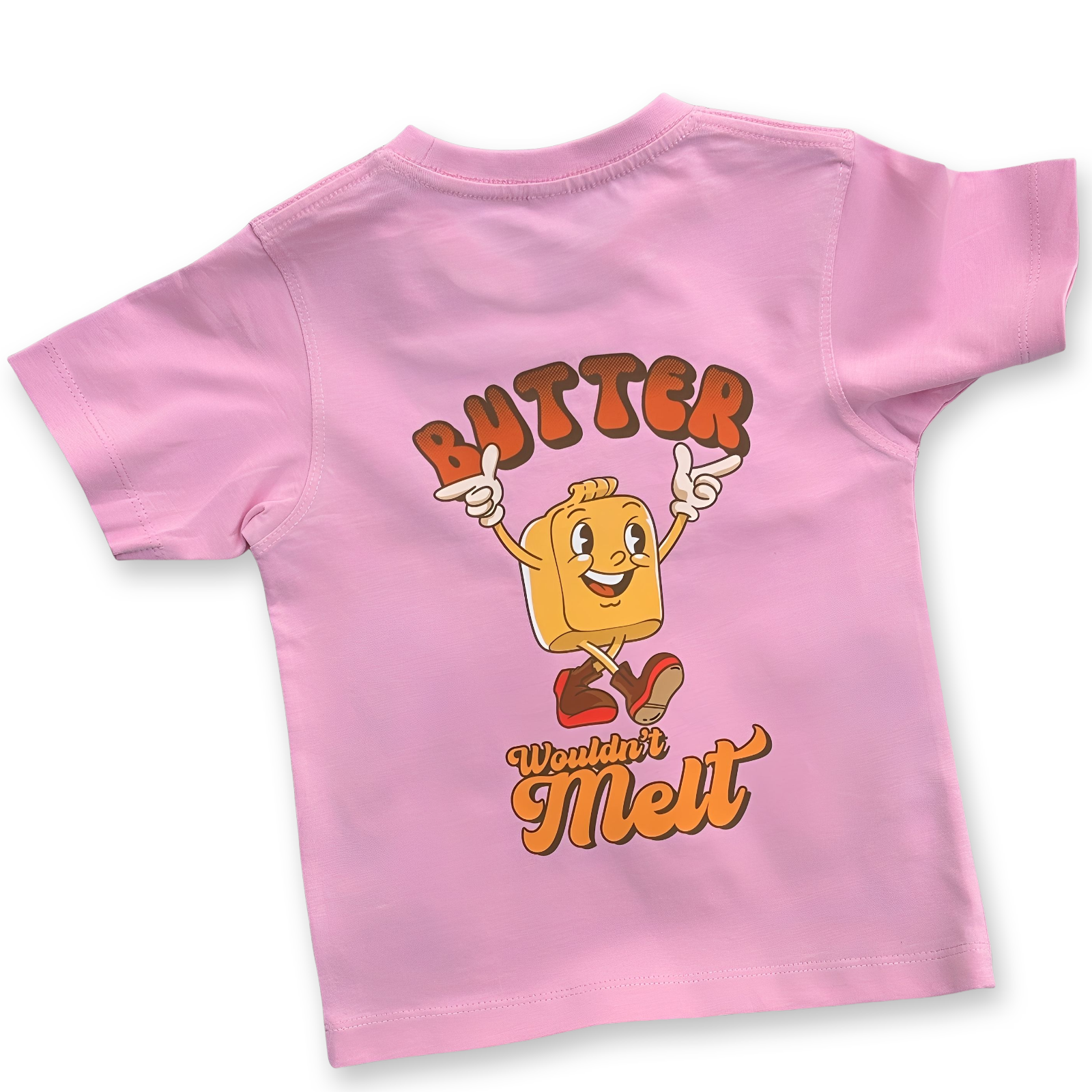 Back of pink kids' t-shirt featuring a large cartoon butter character with red boots and the playful phrase "Butter Wouldn't Melt" in bold retro lettering.
