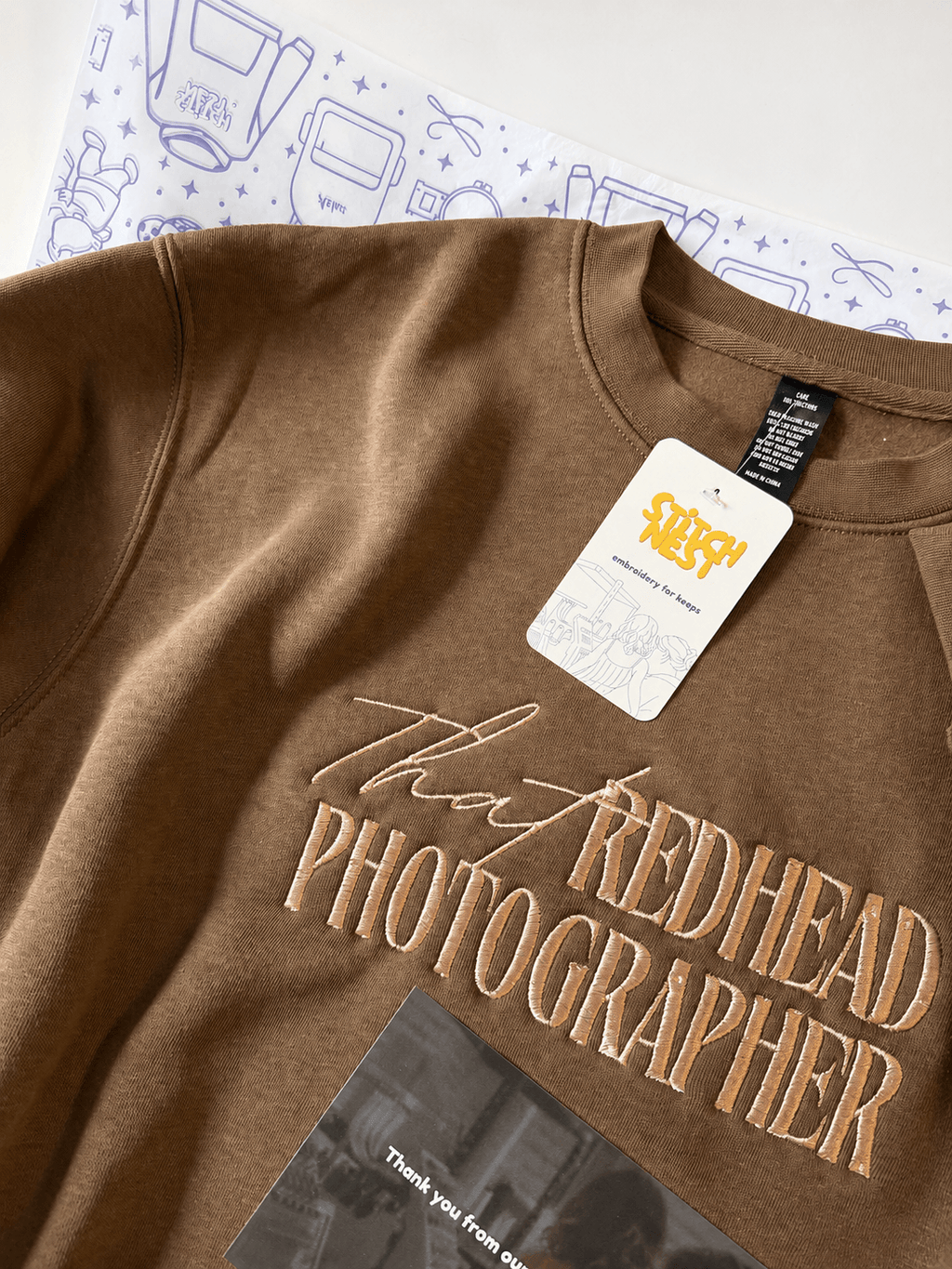 Personalized embroidered sweatshirt featuring brown fleece fabric and stylish text design.