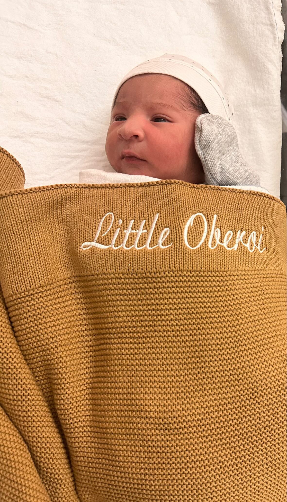 baby in a personalised custom name blanket embroidered with his name