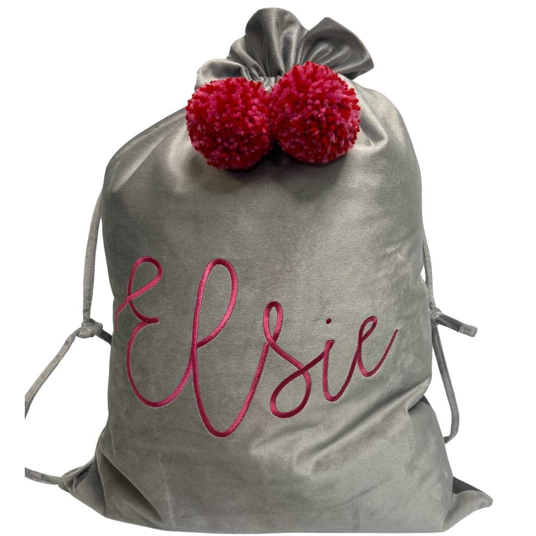 Personalised pink velvet Santa sack with rose pink embroidered name ‘Stella’ and matching pastel pink pom poms.