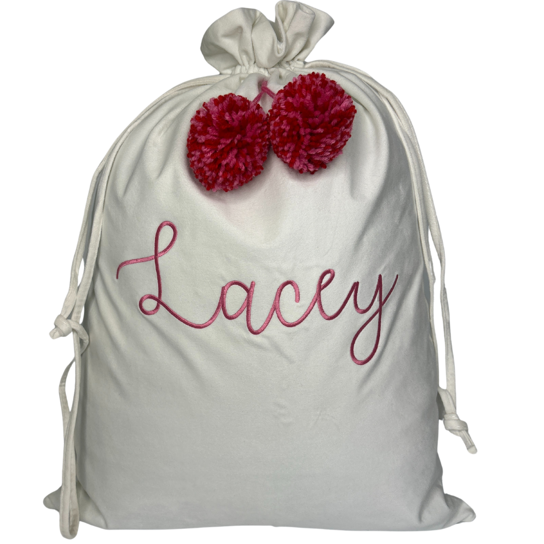 Personalised pink velvet Santa sack with rose pink embroidered name ‘Stella’ and matching pastel pink pom poms.